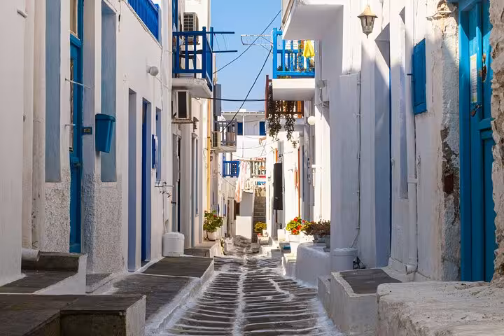 Charming Mykonos Town alley with whitewashed houses and blue doors, featured on a private walking tour