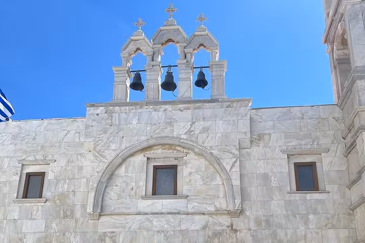 White marble church facade with bell tower in Mykonos Town, featured on a private highlights tour