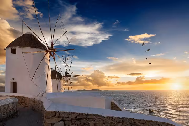 Mykonos windmill at sunset overlooking the Aegean Sea, scenic highlight on a private full-day tour from Athens