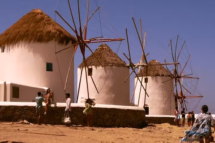 Mykonos windmills at Chora with visitors, iconic stop on Best of the Island Sights and Beaches tour