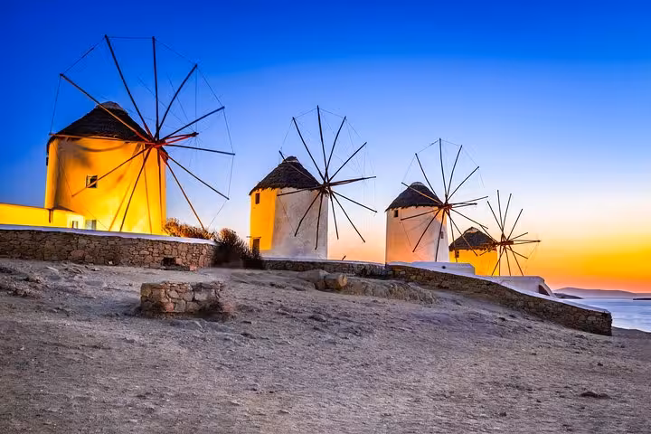 Mykonos windmills at sunset overlooking the Aegean Sea, iconic stop on a From Athens day trip to Mykonos