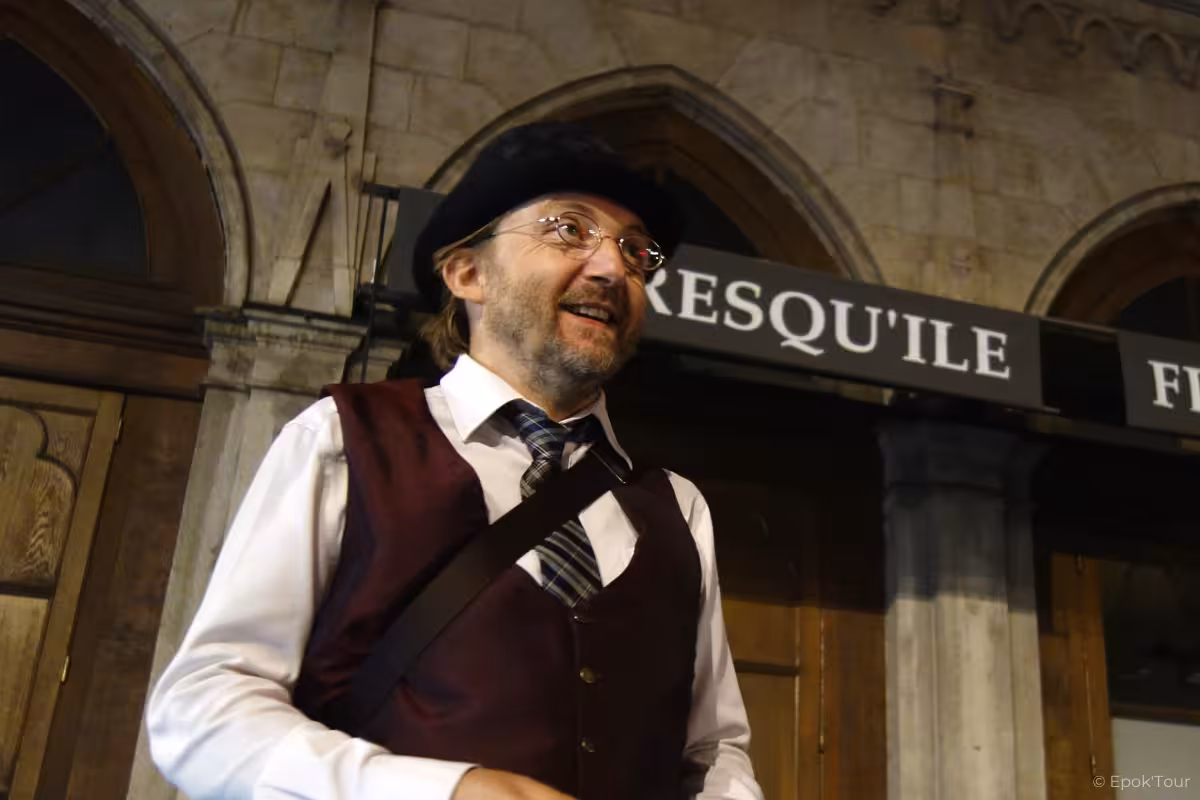 Costumed guide in beret and waistcoat speaking outside historic Lyon stone building at night