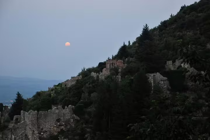 Moonrise over the forested slopes and ruins of Mystras near Sparta on full-day tour including meal