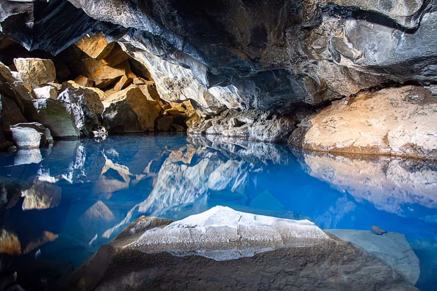 Crystal blue geothermal pool inside a lava cave near Lake Myvatn, Iceland