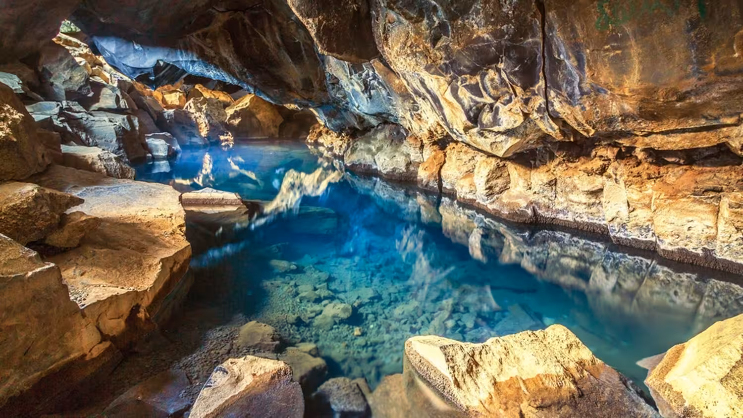 Turquoise geothermal hot spring inside a volcanic lava cave near Lake Myvatn, Iceland