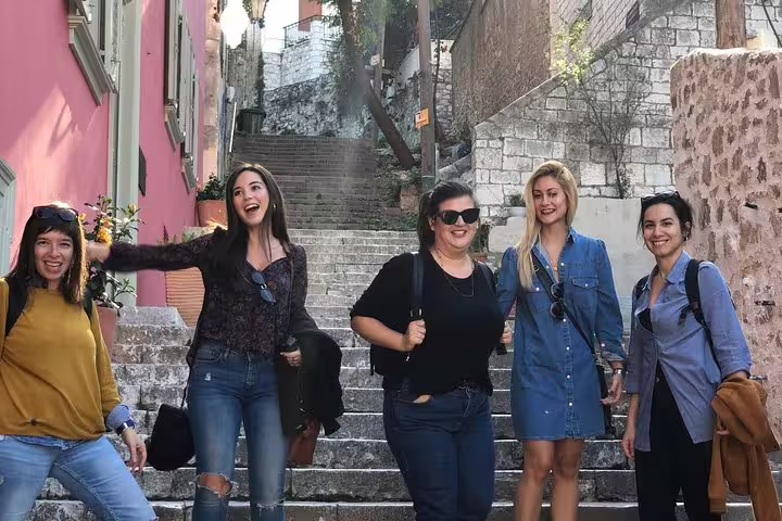 Happy group on Nafplio old town steps, exploring Peloponnese on a private day trip from Athens with local guide
