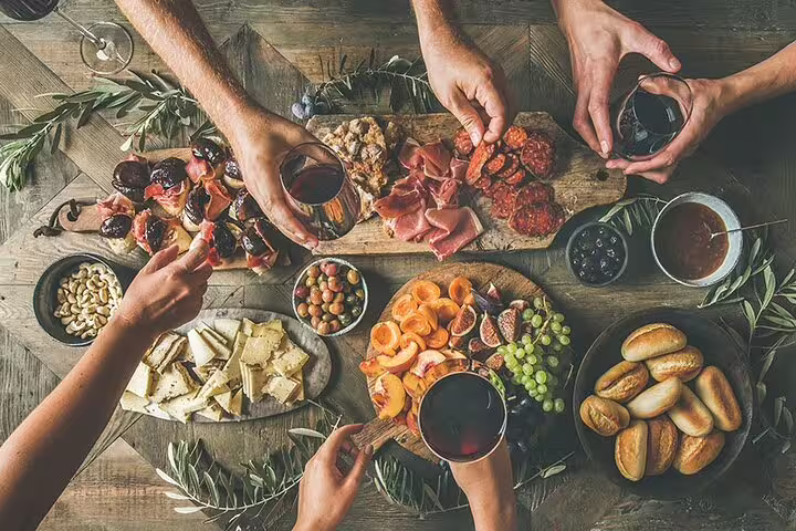 Greek mezze board with cheese, olives and cured meats with red wine, part of Nafplio wine tasting via Corinth Canal