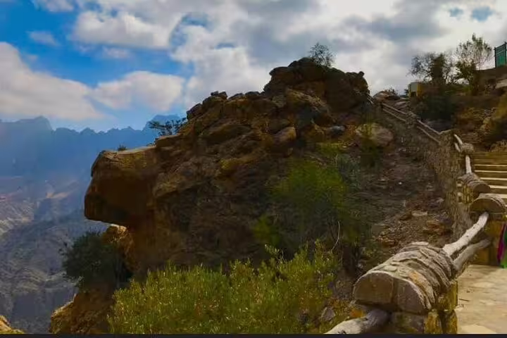 Scenic view of rocky path and lush greenery at Wakan Village, perfect for a full-day tour exploring Nakhal Hotspring.