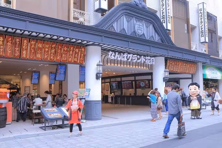 Namba Grand Kagetsu comedy theater entrance with tourists on Osaka food walking tour street