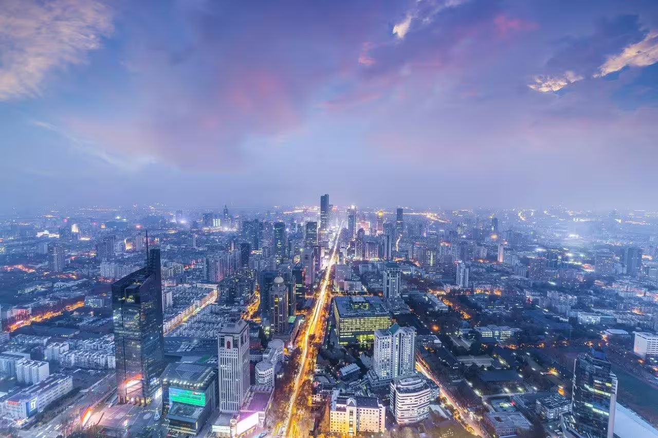 Aerial view of Nanjing's vibrant cityscape at twilight, showcasing modern architecture and bustling streets.