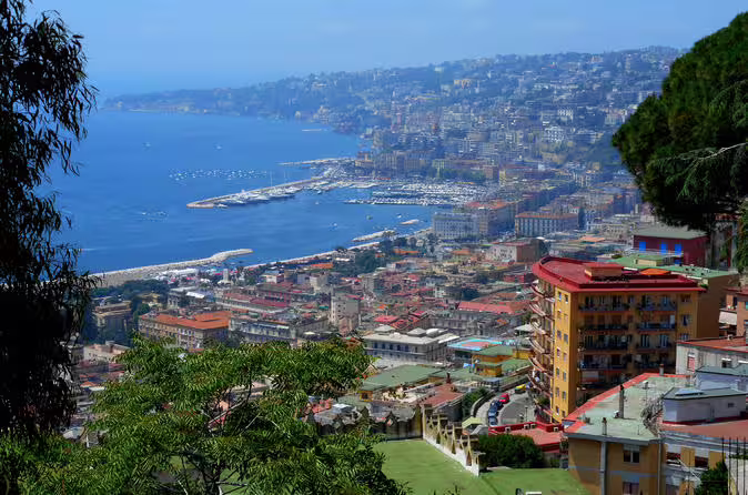 Panoramic view of Naples coastline, colorful hillside buildings and marina along the Bay of Naples on a Rome to Amalfi coast day trip
