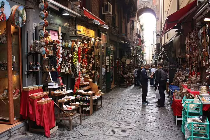 Busy artisan shops and talisman stalls along Via San Gregorio Armeno in Naples, explored on the Legends of Naples walking tour