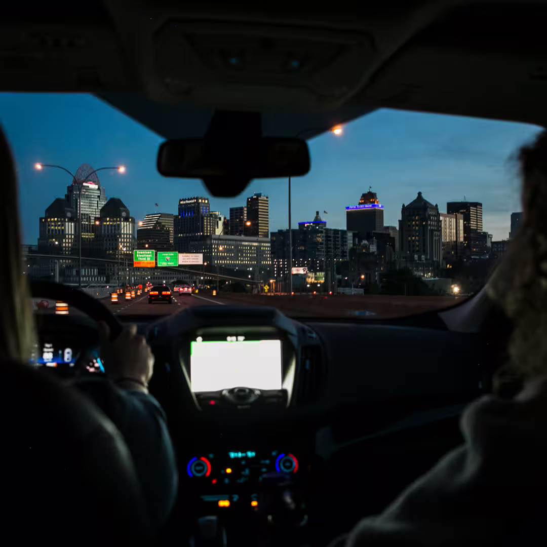 Private car transfer at dusk with illuminated city skyline, ideal for comfortable Naples to Avellino airport or hotel ride