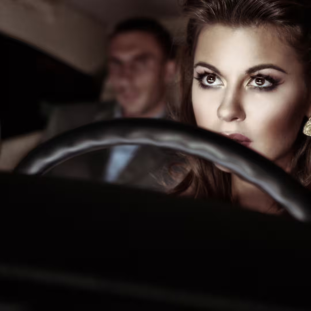 Elegant female chauffeur focused on the road while passenger relaxes during Naples to Avellino private transfer