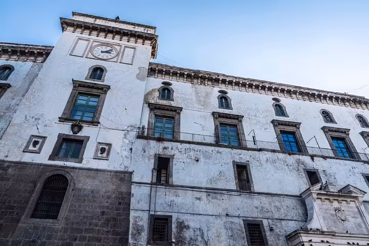 Historic white baroque palace facade with clock tower in Naples city center