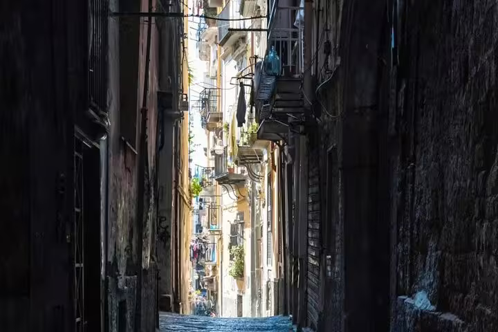 Narrow cobbled alley in Naples’ historic center lined with old buildings explored on the Legends of Naples walking tour