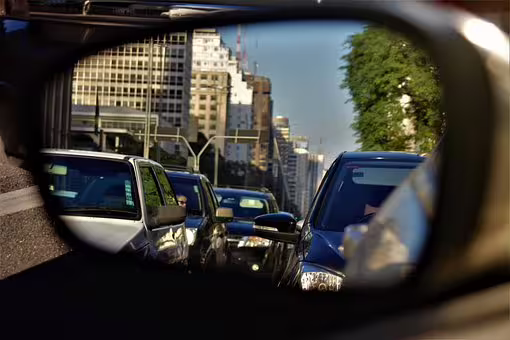 Busy city traffic reflected in car side mirror, highlighting stress-free private transfer option from Naples to Pompeii and nearby towns