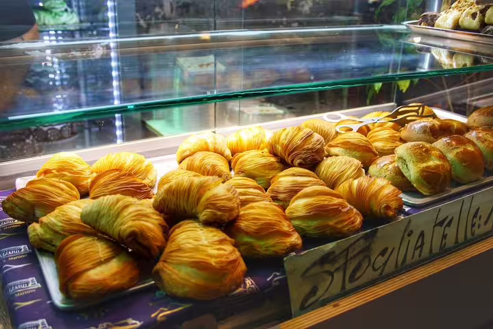 Fresh sfogliatelle pastries displayed in a Naples bakery showcase on an authentic Italian street food tour