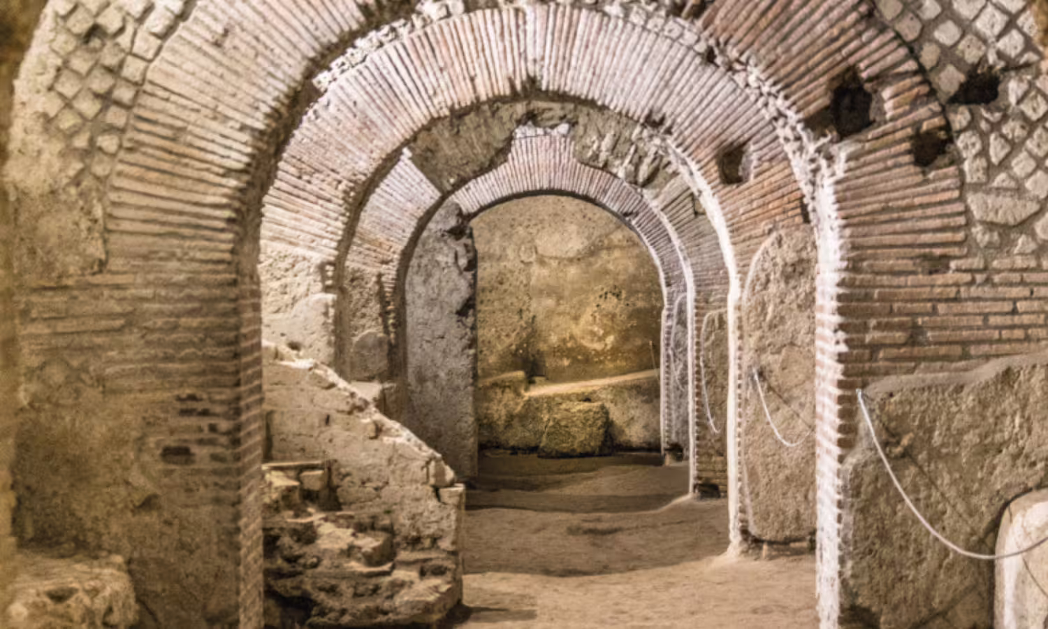 Ancient brick arches and tunnels of the underground Naples archaeological site visited on a 2‑day city discovery tour