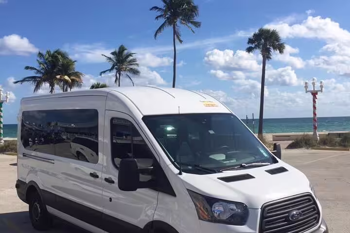 White Ford Transit van parked near Nassau beach with palm trees for private cruise port hotel transfer
