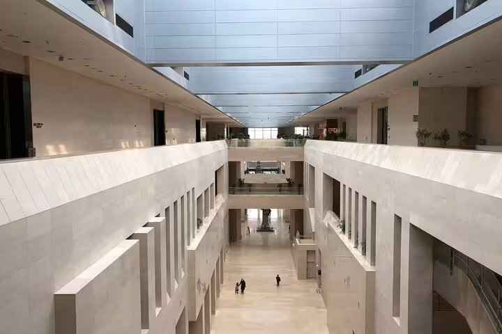 Multi-level white marble atrium interior of the National Museum of Korea in Seoul with visitors below
