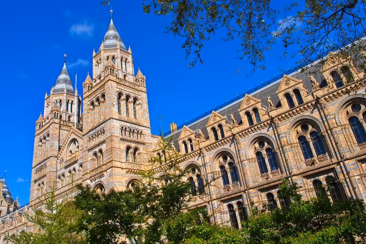 Natural History Museum London exterior facade with ornate Romanesque architecture and twin towers against blue sky