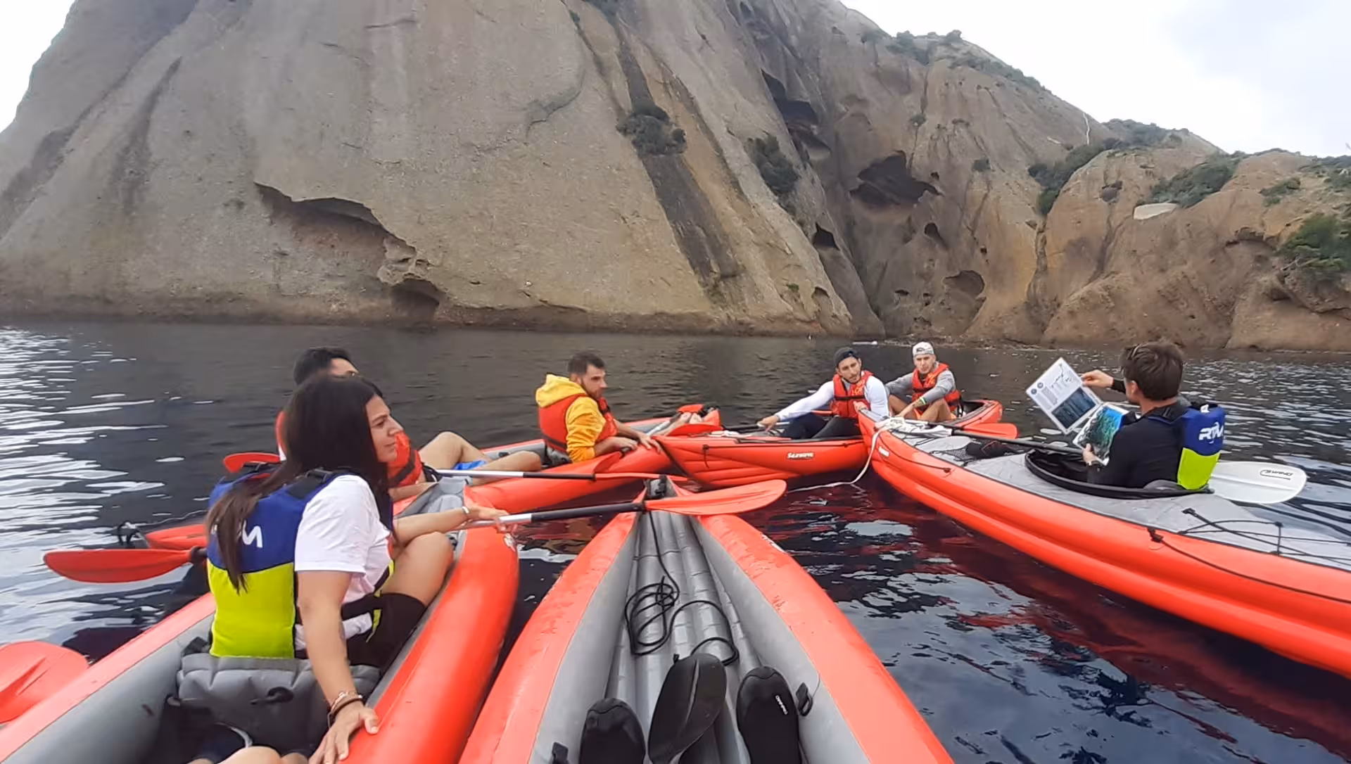 Groupe en kayaks rouges au pied des falaises, briefing du guide sur la sortie naturaliste Embiez Cap Sicié
