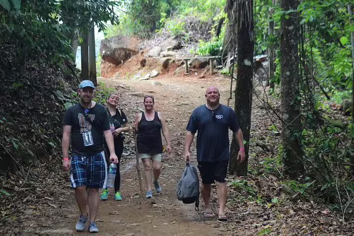 Group of hikers enjoying a scenic trail during the Nauyaca Waterfall hiking tour in lush Costa Rican jungle.