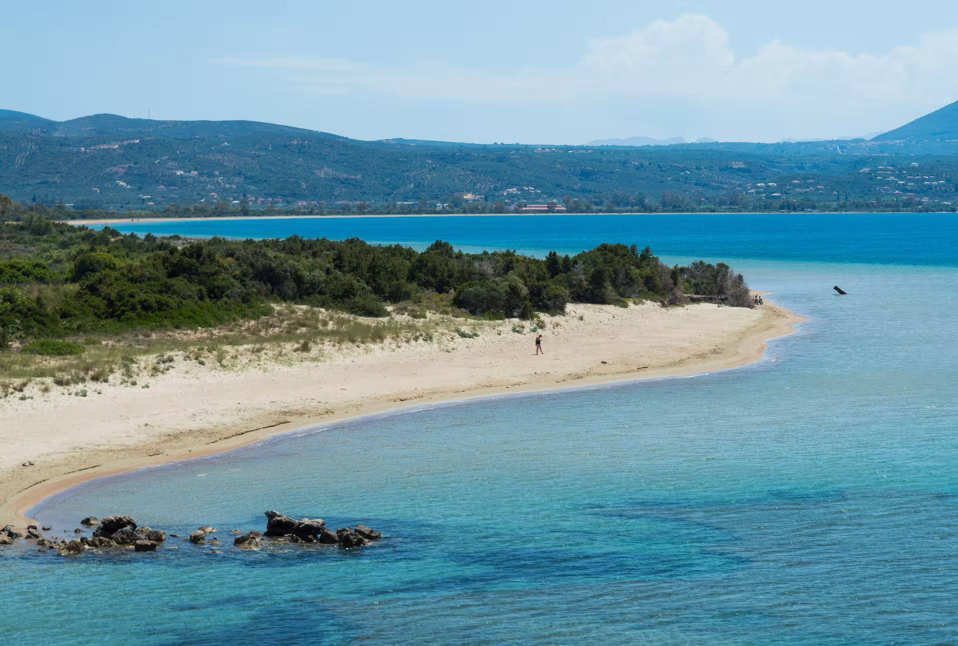 Secluded sandy spit and turquoise waters on Navarino Bay coastal hike near Pylos, Messinia, Greece