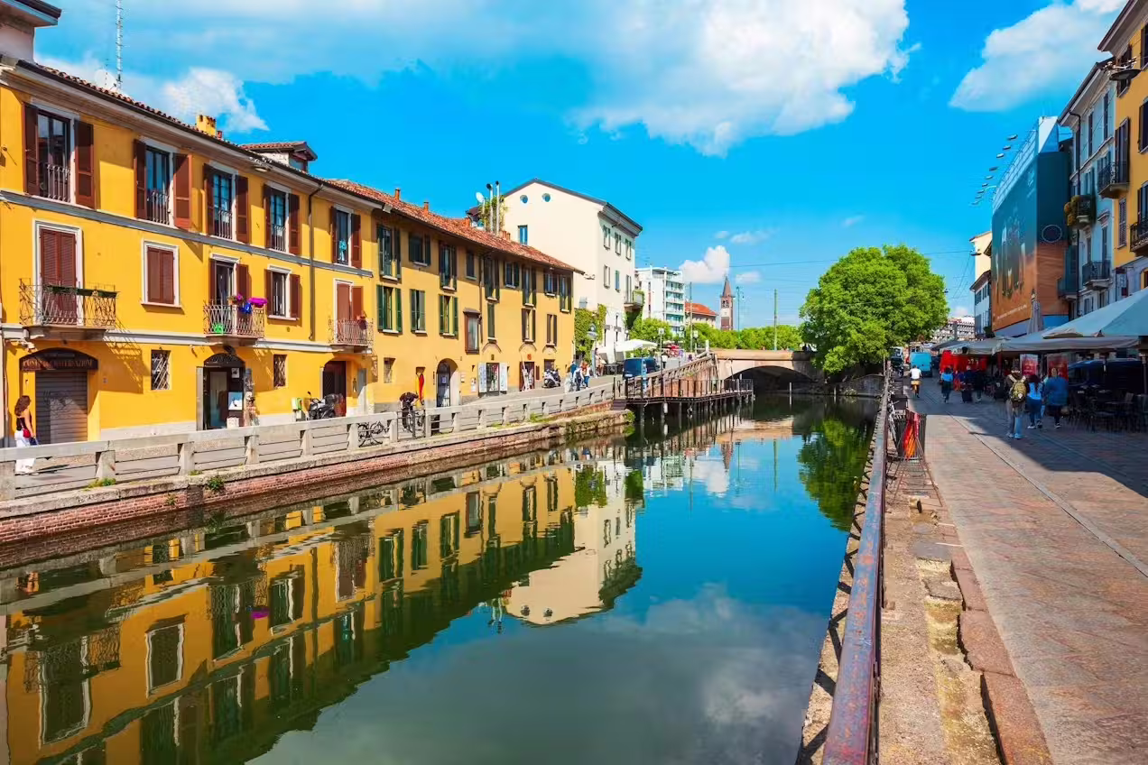Vibrant Navigli canal district in Milan with yellow houses, cafés and reflections, explored on a guided walking tour