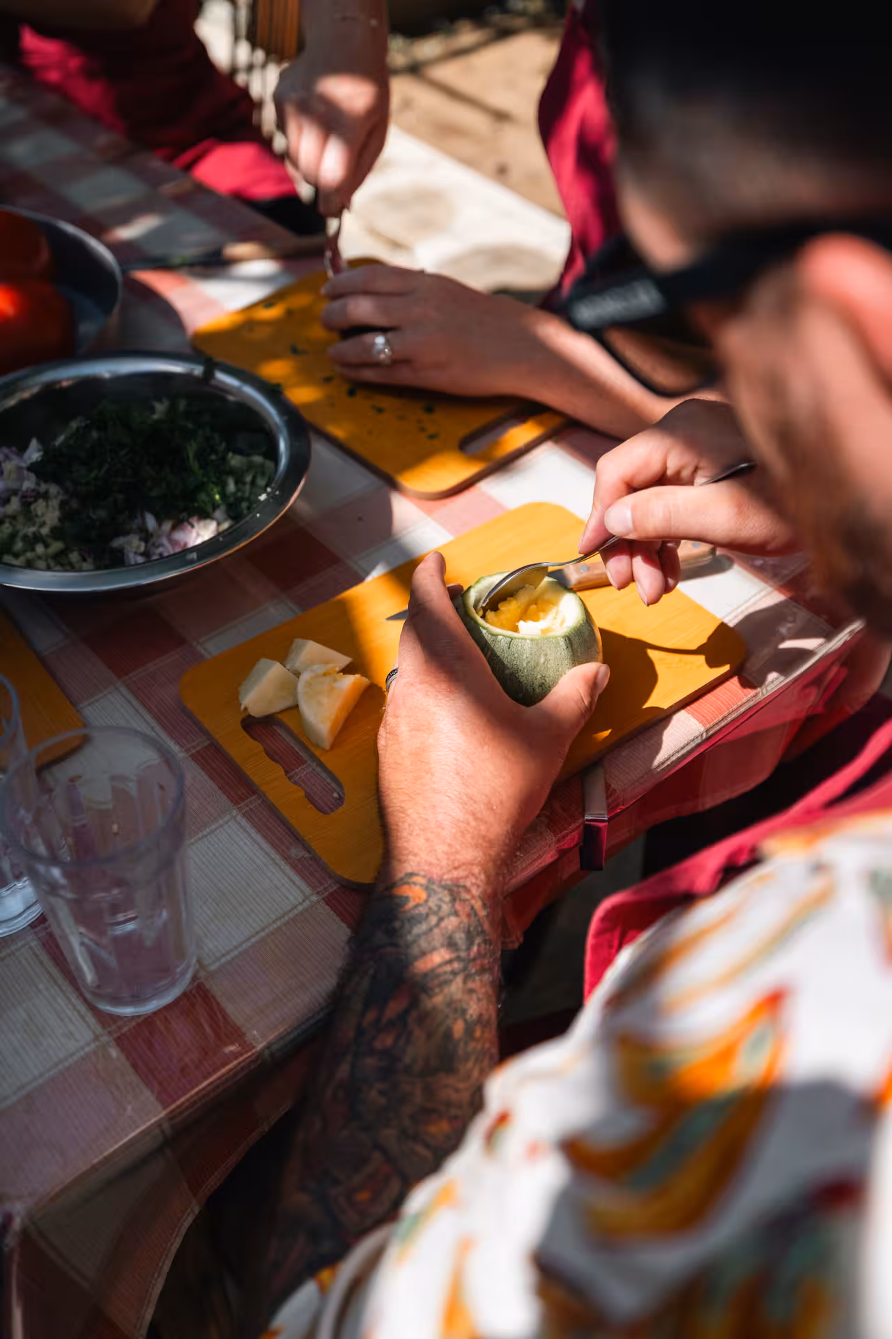 Guests scoop local Naxos cheese filling from zucchini during traditional cooking and cheesemaking class