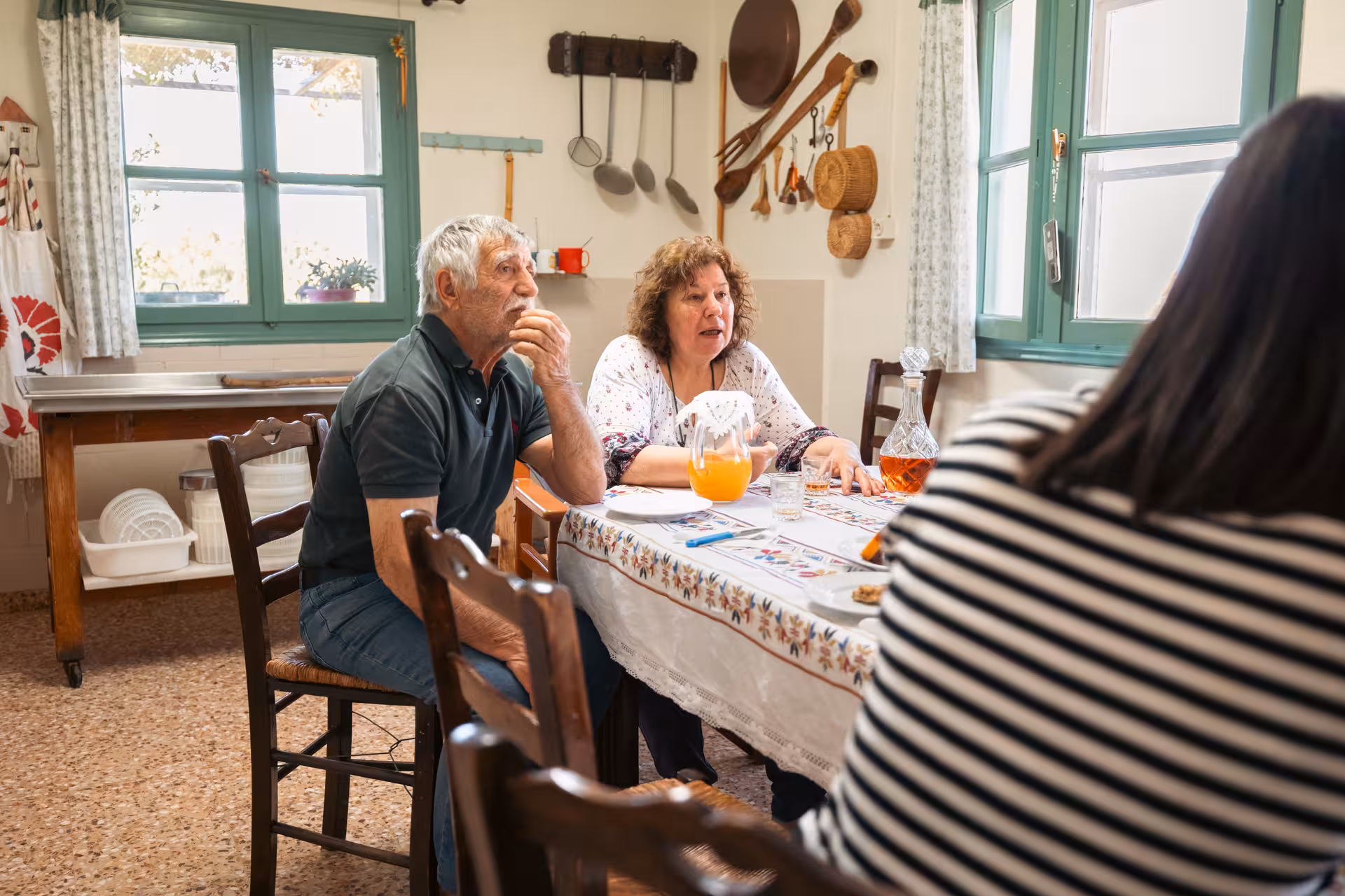 Guests tasting local Naxos wine and cheese in a traditional village kitchen on the Naxos Cheese & Wine Trails tour
