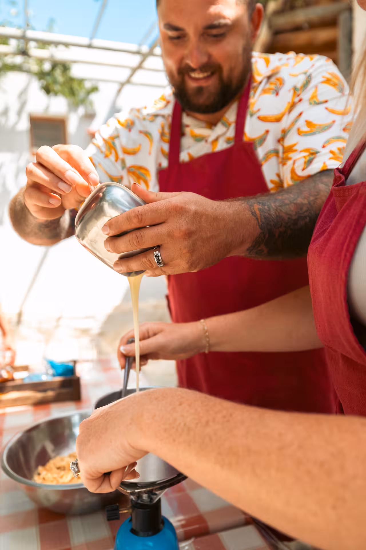Guest pours fresh whey into a pot during Naxos traditional cooking and cheesemaking class in a farm kitchen