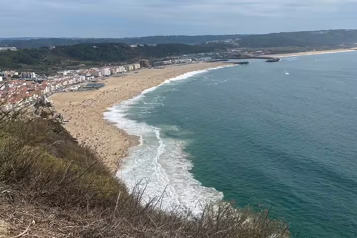 Scenic view of Nazaré's expansive beach and coastline, perfect for a private tour in Portugal's Silver Coast region.