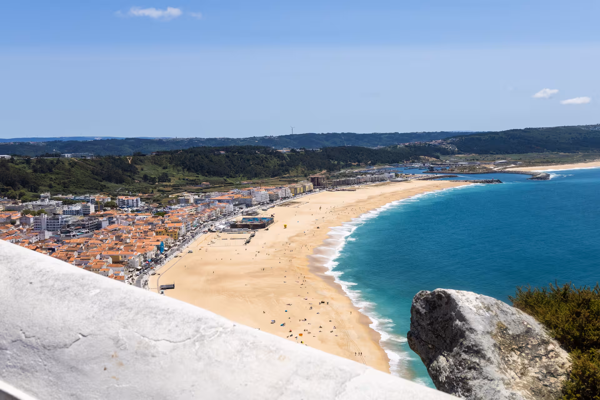 Scenic view of Nazaré's expansive sandy beach and vibrant town, a highlight on the Lisbon to Óbidos tour.