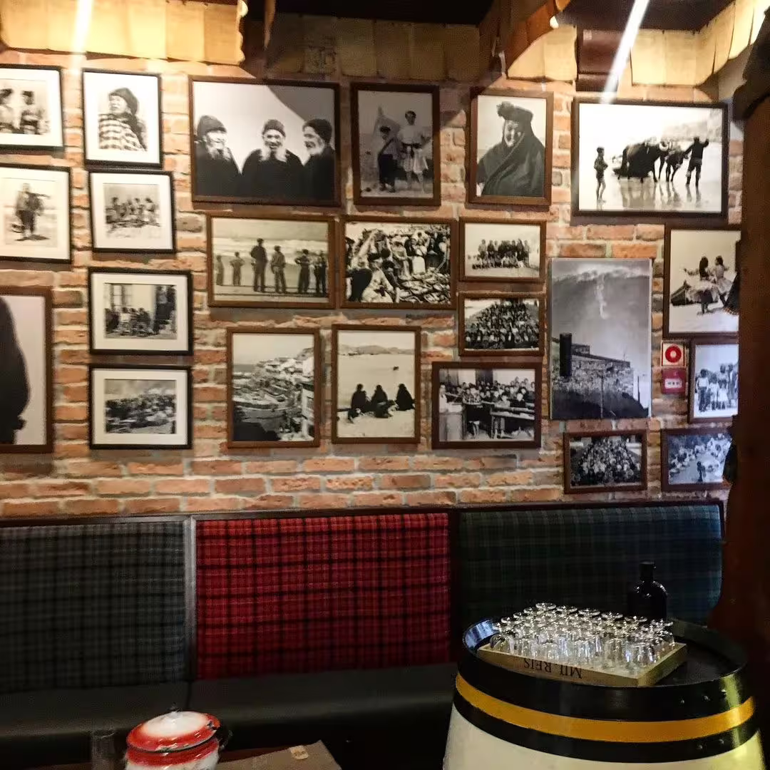 A cozy Nazaré cafe features a rustic brick wall adorned with historical black-and-white photos, offering a cultural glimpse.