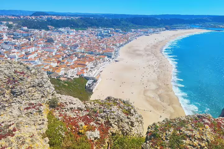 Discover Nazaré's stunning coastline with its expansive sandy beaches and vibrant town, perfect for a seaside adventure.