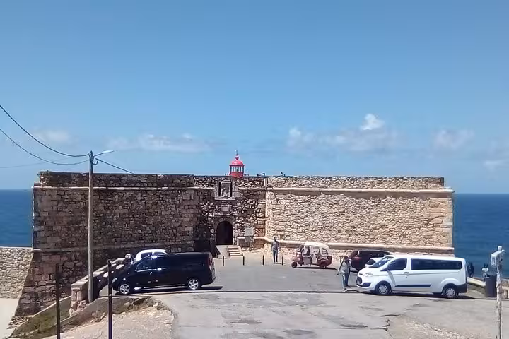 View of the historic Fort of São Miguel Arcanjo in Nazaré, showcasing its iconic red lighthouse against the ocean backdrop.