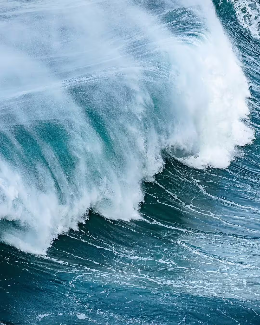 Massive ocean wave crashing at Nazaré, Portugal, showcasing the thrilling giant waves surf experience adventure.