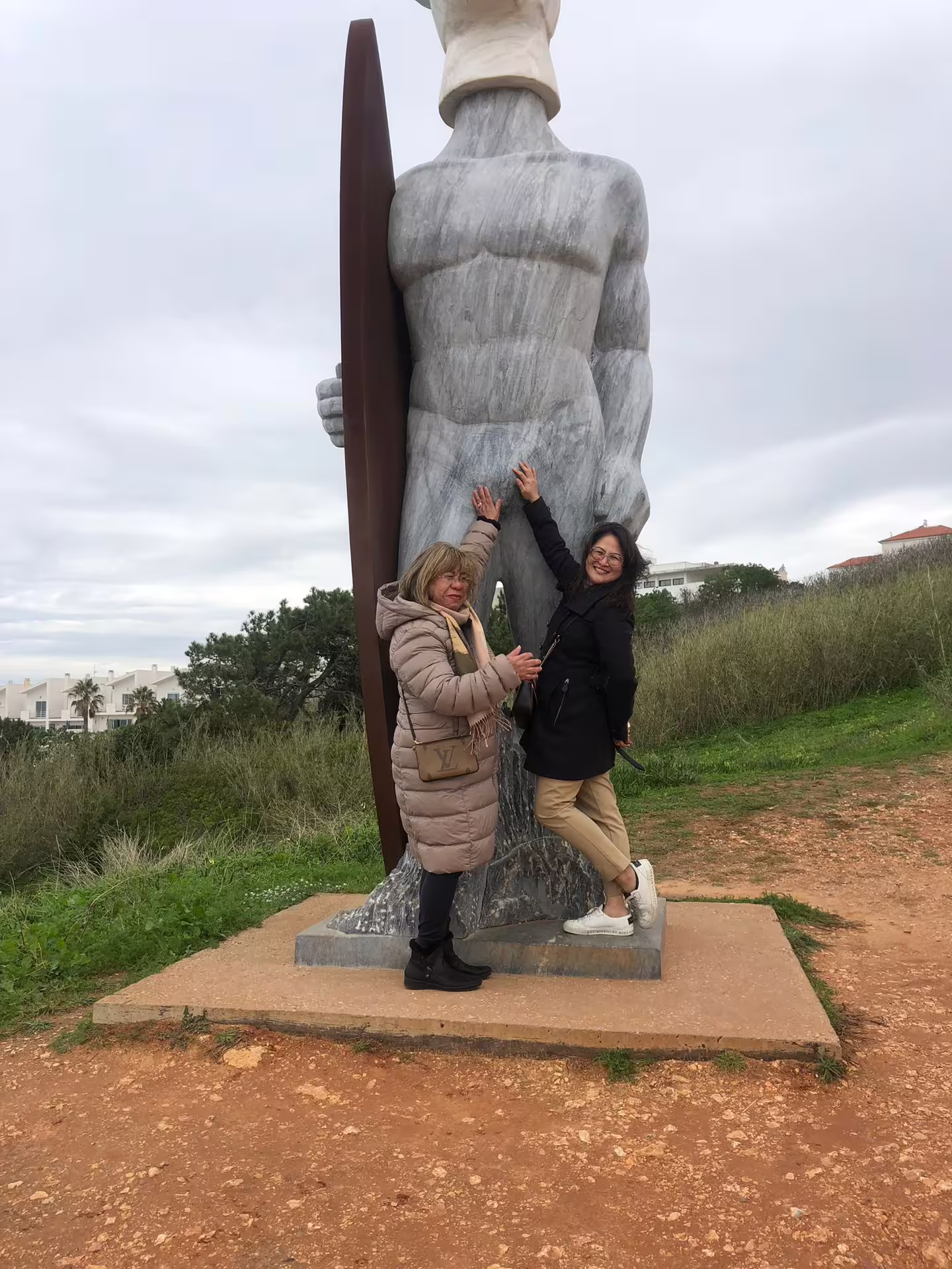 Visitors enjoy a moment with the iconic Nazaré surfer statue on the Fátima, Nazaré, Batalha, and Óbidos tour.
