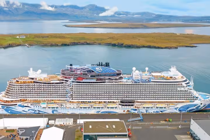 NCL Norwegian cruise ship docked at Reykjavik cruise port with Icelandic landscape in background