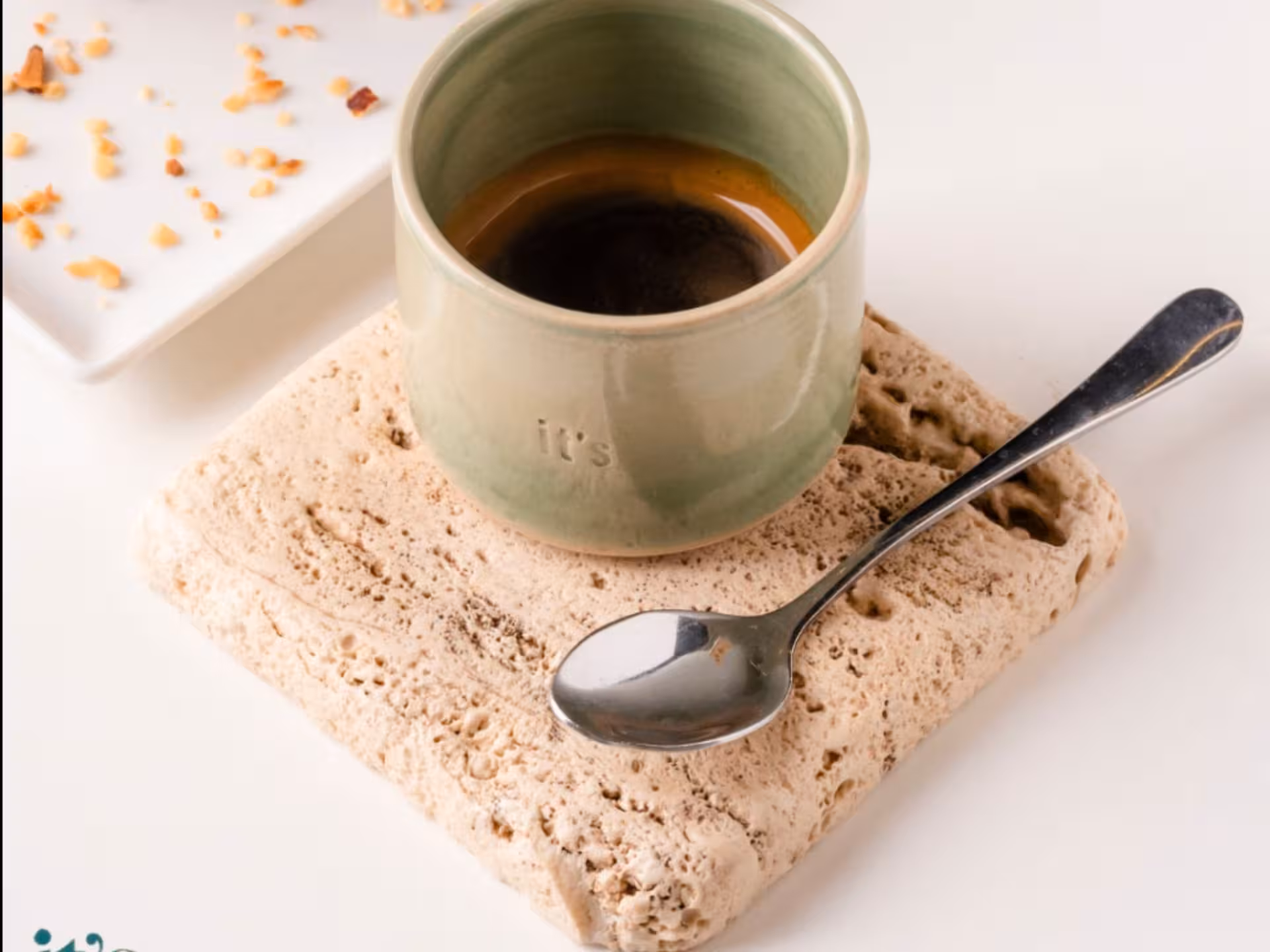 Elegant espresso cup on a textured coaster, perfect for a Neapolitan coffee experience.