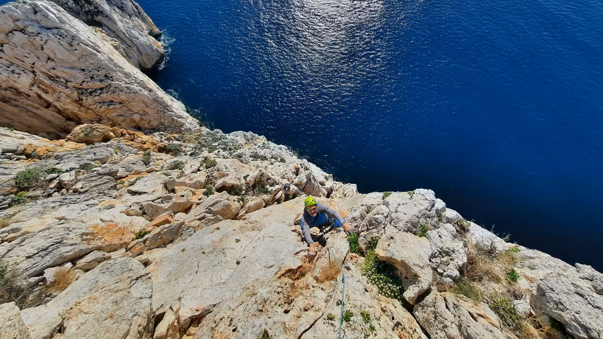Adventurous climber tackles the steep Masua cliffs with stunning sea views in Nebida, ideal for thrill-seekers.