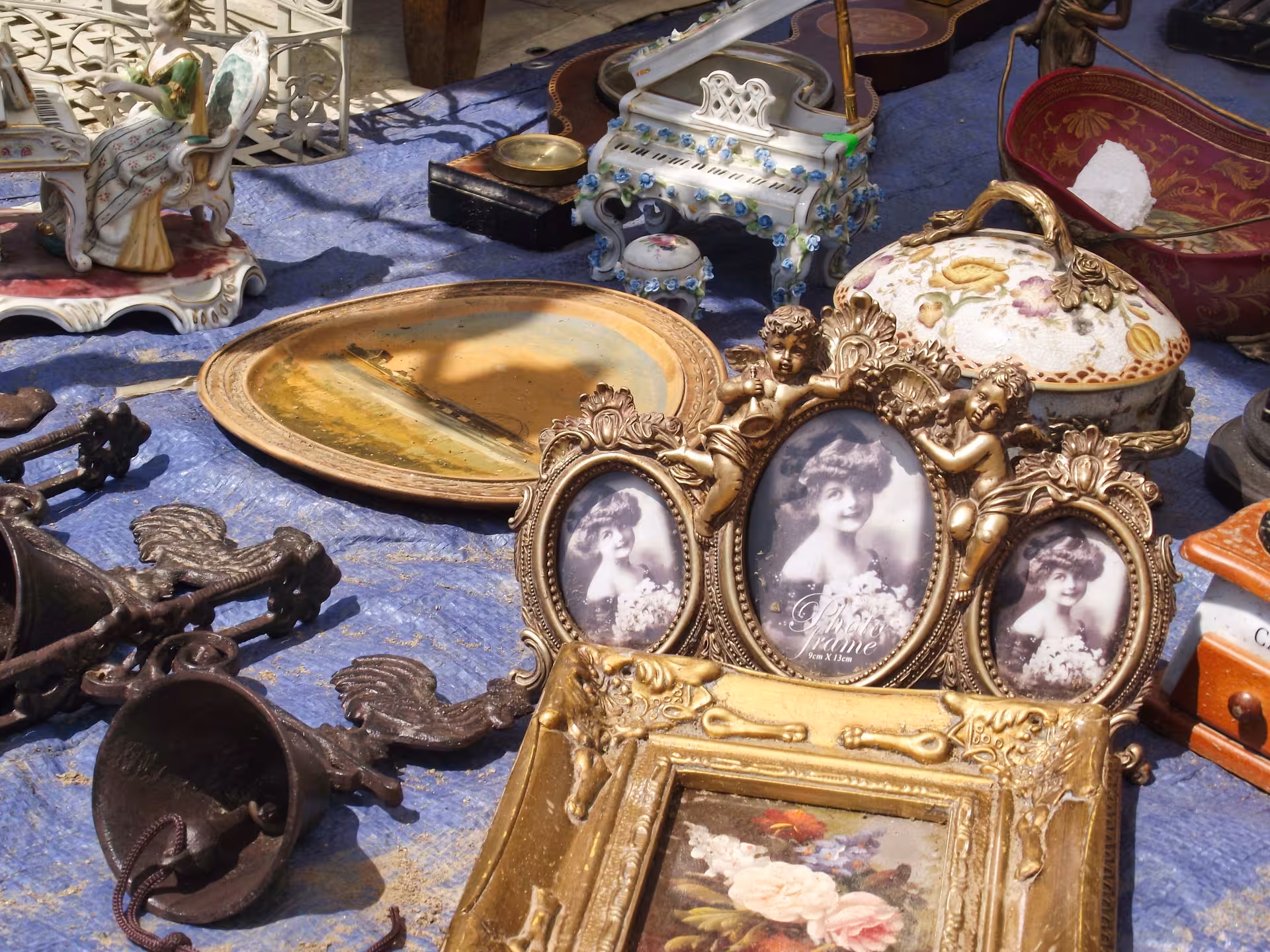 Ornate vintage gold frames, porcelain figurines, and antique collectibles displayed at Negreni Flea Market guided tour