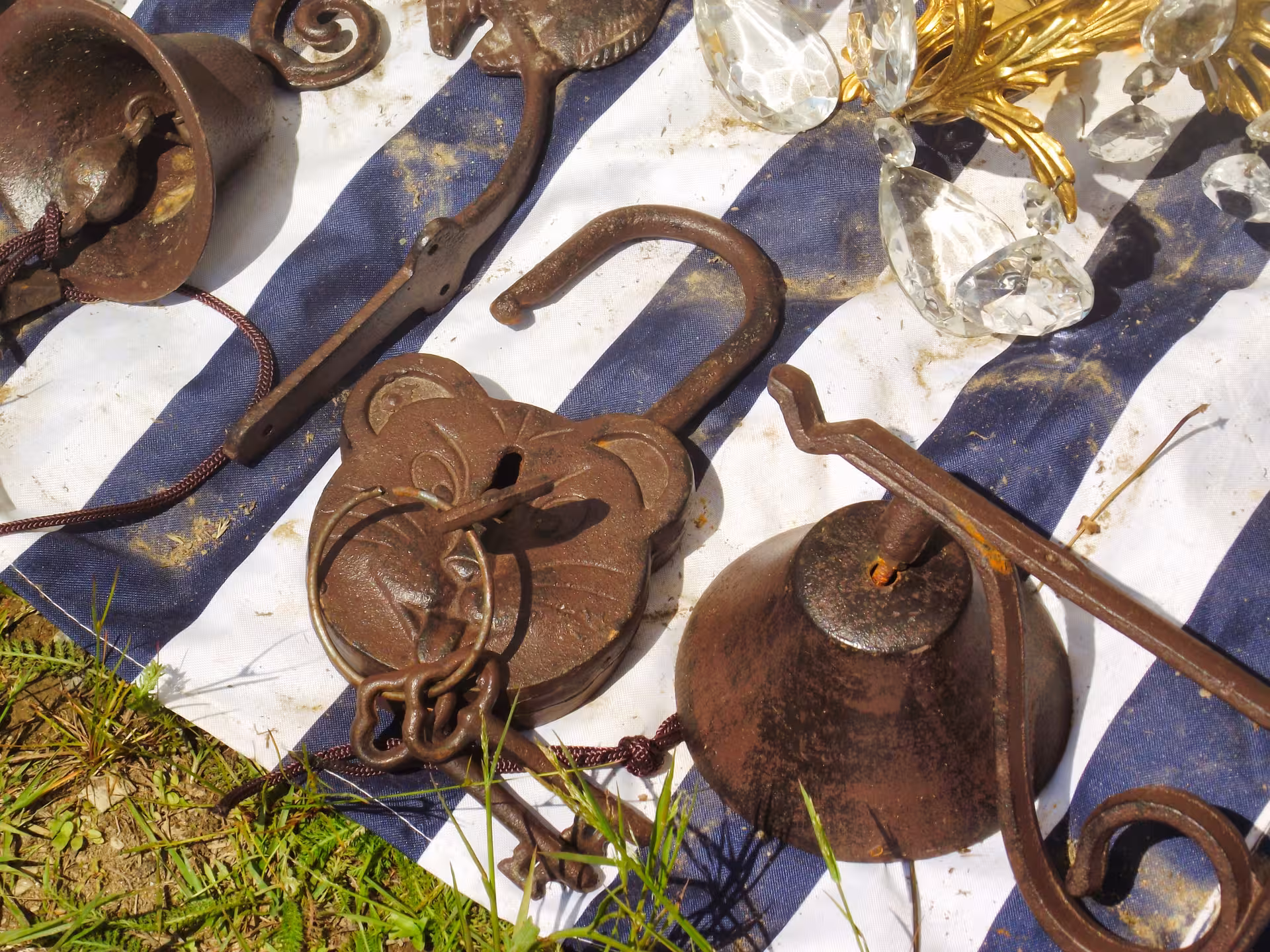 Rusty antique iron padlock bells and crystal chandelier pieces displayed at Negreni Flea Market guided tour