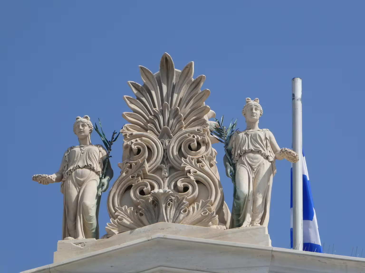 Neoclassical statues and ornate rooftop detail in Athens, near Plaka and Monastiraki walking tour route