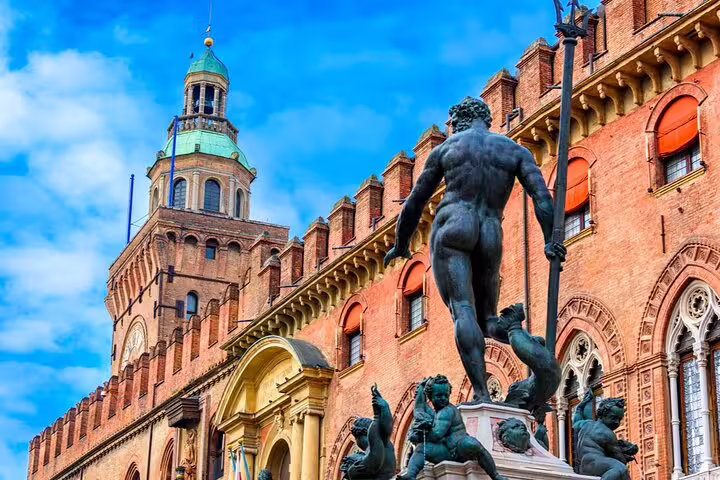 Fountain of Neptune bronze statue with Bologna's Palazzo d'Accursio medieval brick facade in background