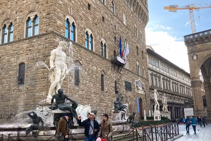 Visitors admire the Neptune Fountain at Piazza della Signoria in Florence, part of the Rome to Florence tour.