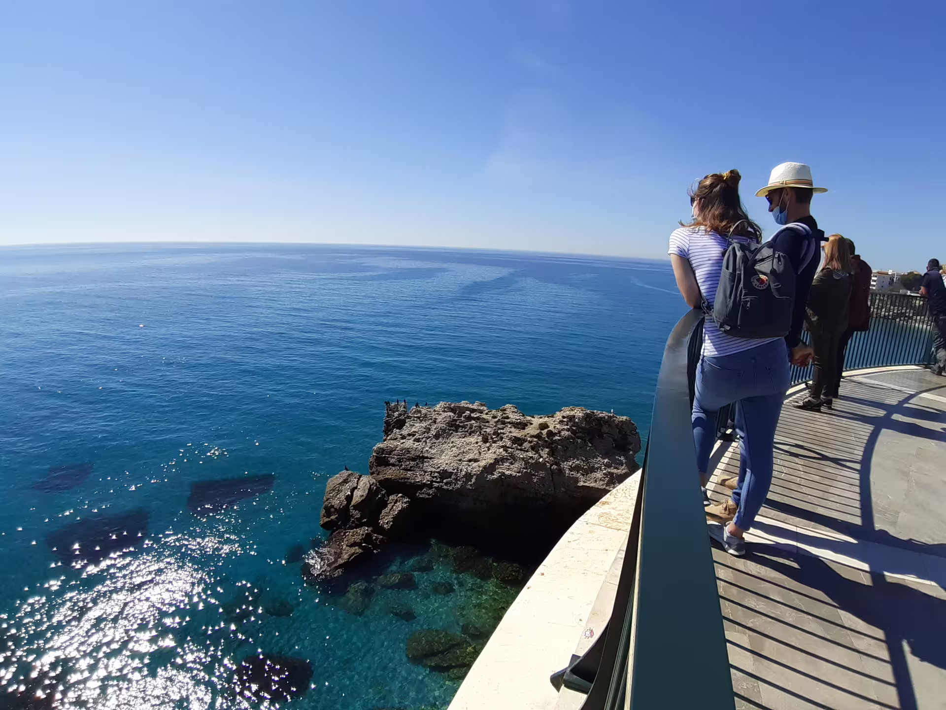 Tourists on Nerja Balcón de Europa viewpoint overlooking turquoise Mediterranean on private Marbella pickup tour