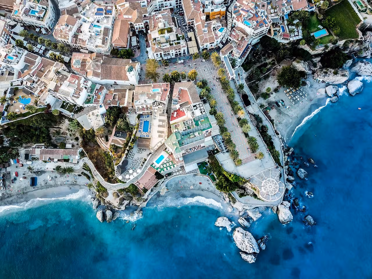 Aerial view of Nerja's charming coastal town with vibrant architecture, inviting beaches, and stunning Mediterranean Sea.